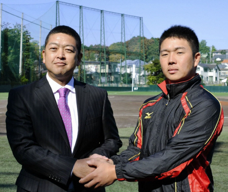 慶大・大久保新監督（左）は、新主将の横尾とガッチリ握手＝横浜市の慶大グラウンド
