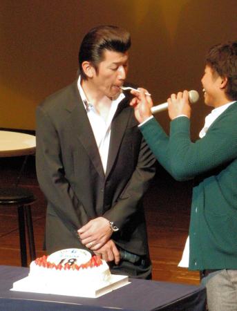 　トークショーで誕生日ケーキを送られ若手の桑原（右）にケーキを食べさせてもらう三浦