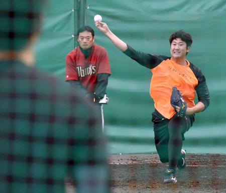 相川（手前）を相手にブルペンで投球練習をする菅野