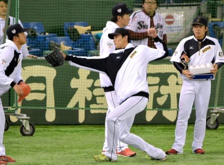　練習中、派手なアクションでストライクのポーズを連発する藤浪（中央）。右は松井裕、左は沢村