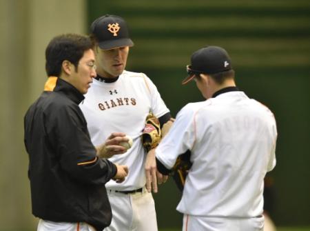 　豊田投手コーチ（右）と握りを確認するポレダ（中）