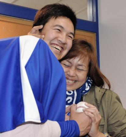 ウイニングボールを手渡し、母・ベリアさん（右）と抱き合う山崎（撮影・吉澤敬太）
