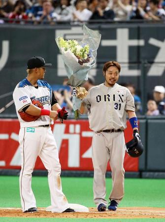 　５回、通算千安打を達成し、花束を手にするオリックス・小谷野。左は日本ハム・中田＝札幌ドーム