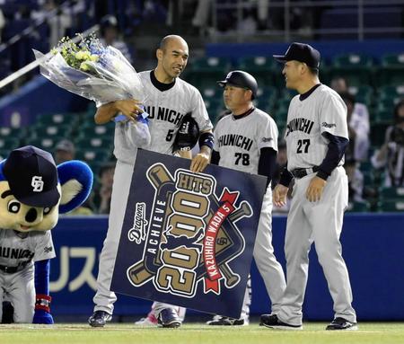 　２回、和田（左）は左翼線に２０００本目の安打を放ち、谷繁監督兼選手（右）から花束を受け取る