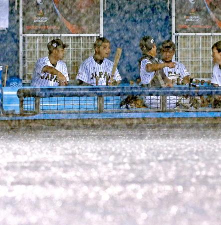 　試合開始直前に激しい雨が降りだし、ベンチで待機する清宮（中央左）ら日本ナイン（撮影・飯室逸平）