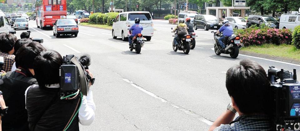 清原和博被告のが乗っていると思われる車両を写す報道陣と追いかけるバイク＝東京地裁前