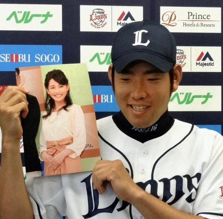　深津瑠美さんの写真を手に、笑顔で結婚を報告する菊池