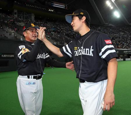 　ウイニングボールを手に工藤監督（左）とタッチを交わす和田