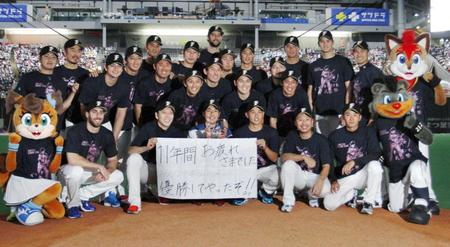 　メッセージを掲げ、投手陣らと記念写真に納まる日本ハム・武田勝（前列左から３人目）＝札幌ドーム