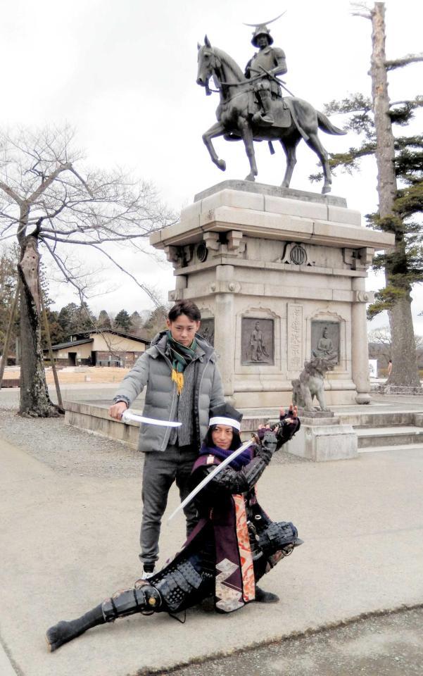 　仙台市・青葉山公園の伊達政宗公騎馬像前でポースを取る平沢。右は政宗の重臣として仕えた片倉小十郎重綱にふんした関係者