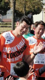 2020年東京五輪応援イベントで参加者と笑顔でハイタッチする三浦投手コーチ=横浜・象の鼻パーク