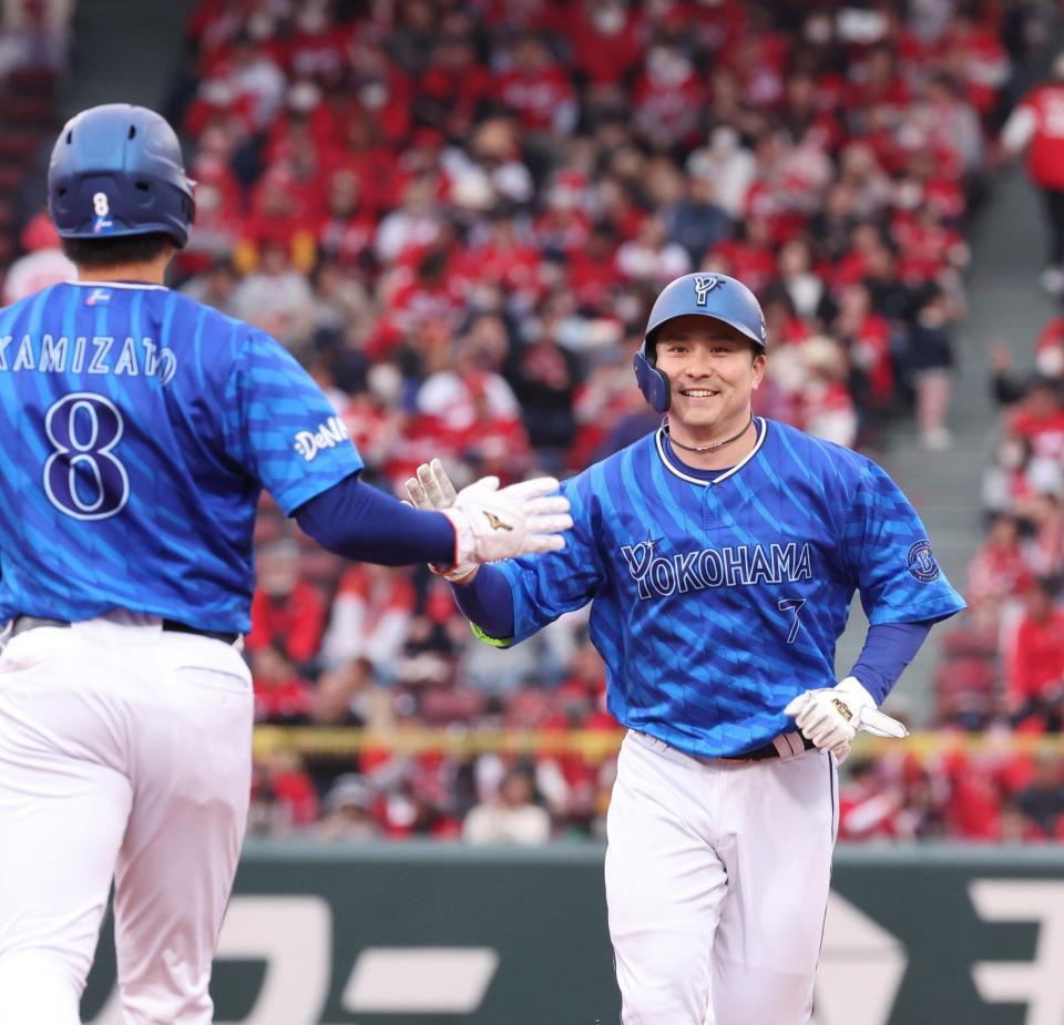 　９回、左翼への２点タイムリー二塁打を放ち、笑顔でタッチを交わす佐野（撮影・市尻達拡）