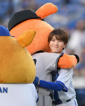 　セレモニアルピッチ後、ジャビットにハグされ複雑な表情の高橋優斗（撮影・伊藤笙子）