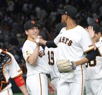 　マルティネス（右）からウイニングボールを受け取り、笑顔を見せる大勢（撮影・西岡正）