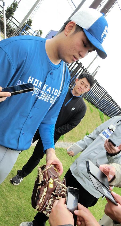 　金孫の文字が刺しゅうがされたグラブを見せる古林