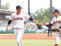 　３回、無失点に抑え、浦田（右）とタッチを交わす戸郷（撮影・西岡正）