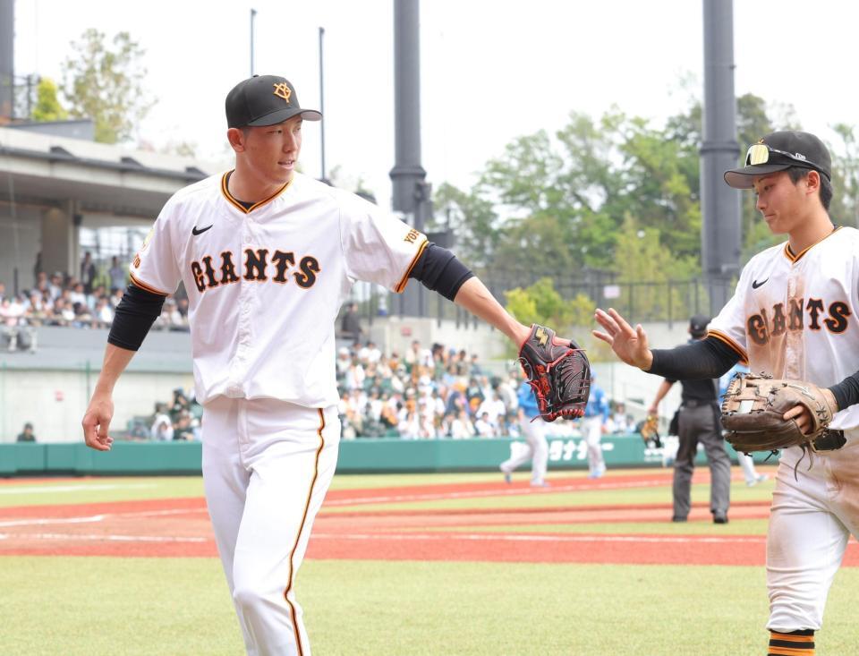 　３回、無失点に抑え、浦田（右）とタッチを交わす戸郷（撮影・西岡正）