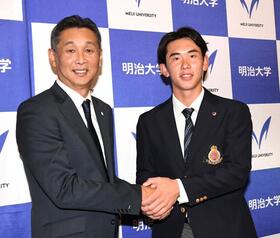 　ドラフト会場から駆けつけた西口監督（左）と握手を交わす明大・小島大河（撮影・佐藤厚）