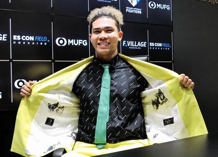 　契約更改を終え、愛犬をデザインしたスーツの裏地を披露する水谷