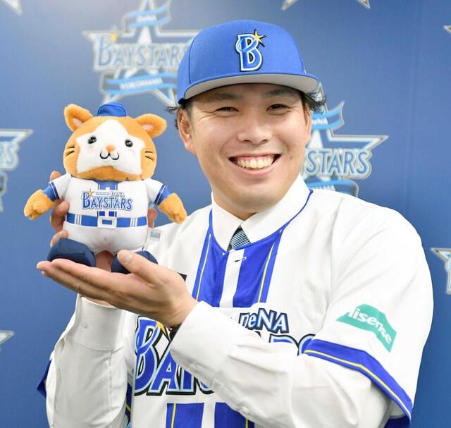 　入団会見でマスコットのスターマンを手に笑顔の馬場（撮影・開出牧）