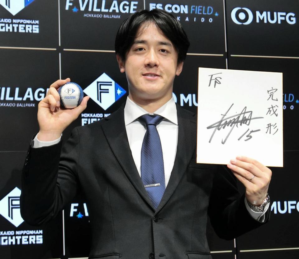 　契約を更改し、ボールと色紙を手にポーズをとる北山