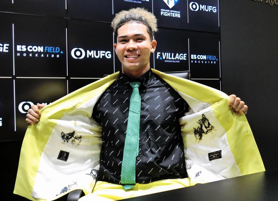 　契約更改を終え、愛犬をデザインしたスーツの裏地を披露する水谷