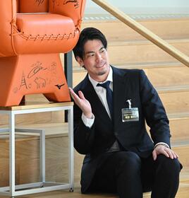 　ミズノブランドアンバサダーミーティングに参加し、イラストの前でポーズをとる前田