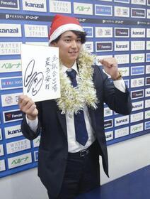 　契約更改交渉を終え、来季の抱負を記した色紙を手にポーズをとる西武・西川