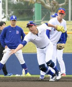 　早出練習で川崎宗則臨時コーチ（手前）の守備を見る新保（右）