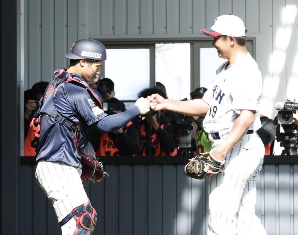 ブルペンでの投球を終え、グータッチする坂本（左）と菅野（撮影・伊藤笙子）