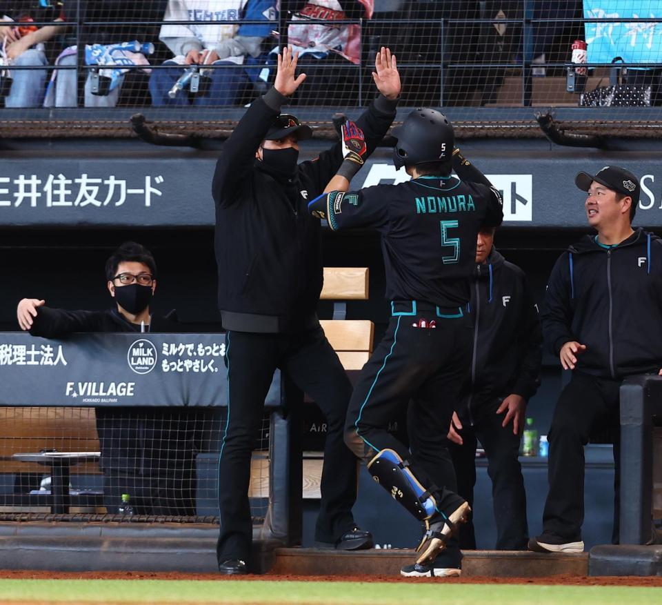 ９回、２ランを放った野村（５）をハイタッチで迎える新庄監督（中央）＝撮影・中島達哉