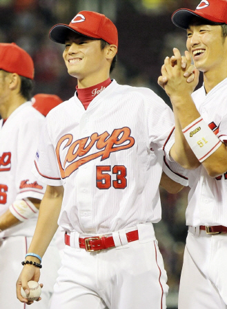 プロ初勝利を挙げ、ウイニングボールを手に笑顔を見せる広島・戸田（左）＝マツダスタジアム