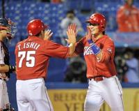 1回、先頭打者アーチを放った広島・鈴木誠也が石井琢コーチ(左)と笑顔でタッチする=神宮球場(撮影・園田高夫)