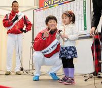 トークショーのじゃんけん大会で勝った女の子の隣でVサインを見せる一岡(左は木村)