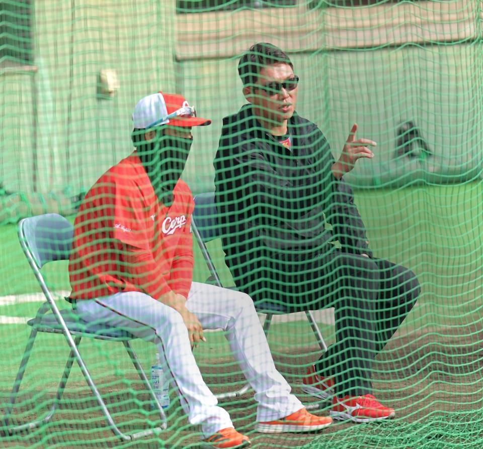 紅白戦をネット裏から観戦し、藤井ヘッドコーチ（左）と話をする新井監督