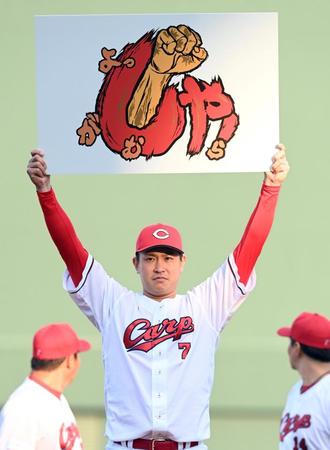 　来季のスローガン「しゃ！」と記したボードを掲げる堂林（撮影・田中太一）