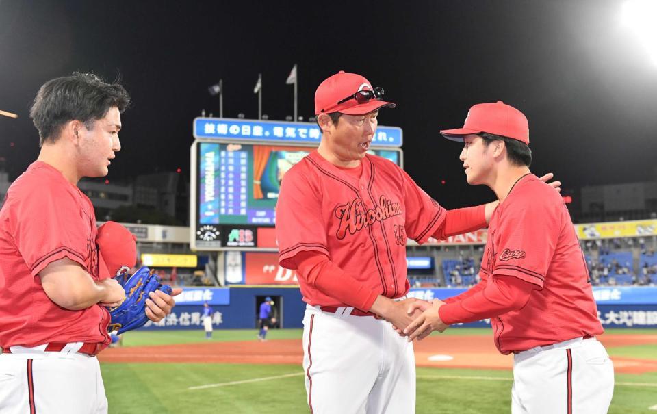 　新井監督と握手をするプロ入り初勝利の黒原（撮影・佐々木彰尚）