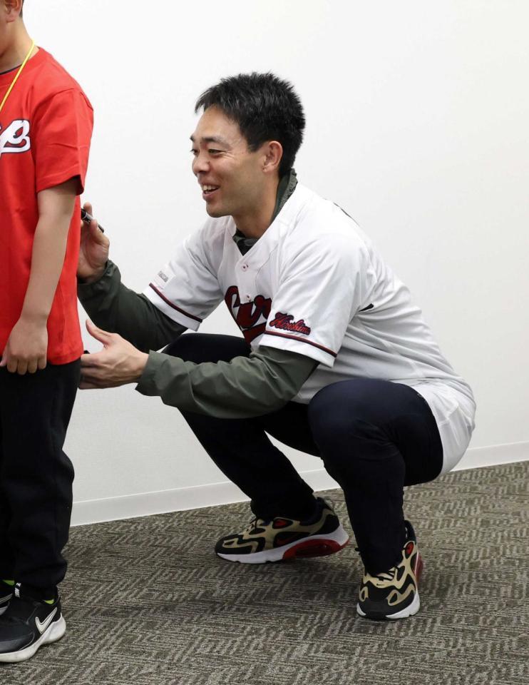 　ひとり親家庭の親子を招待し、サインをする秋山（撮影・市尻達拡）