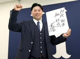 　来季の目標を記し、ポーズを決める末包（撮影・市尻達拡）