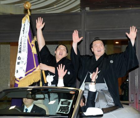 　白鵬（右）の旗手としてパレードカーに乗り、万歳をする遠藤（左）＝撮影・吉澤敬太