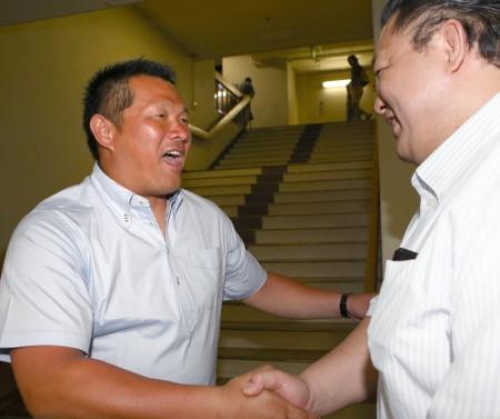 　元大関魁皇の浅香山親方（右）と笑顔で握手する山崎武司氏