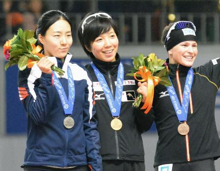 　女子５００メートルで初優勝し表彰式で笑顔の小平奈緒（中央）。左は２位の李相花＝ソウル（共同）