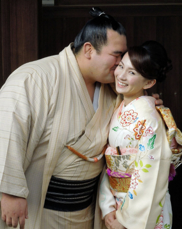 婚約を発表し、祐未さん（右）の頬にキスする琴奨菊