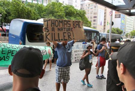 　ＩＯＣの理事会が開かれたホテル前で、メッセージを掲げて環境破壊に抗議する男性＝２月２８日、リオデジャネイロ（共同）