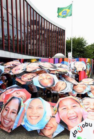　間もなく開幕するリオデジャネイロ五輪を応援しようと掲げられた、ブラジルと日本の子どもたちの「笑顔の傘」＝２８日午後、東京都港区のブラジル大使館