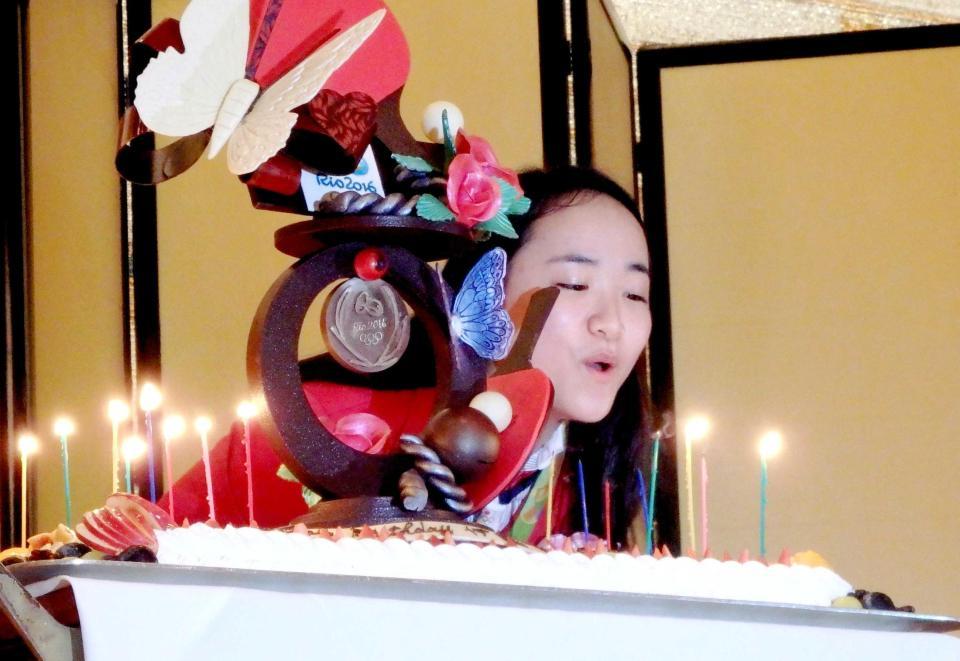 　サプライズで用意された誕生日ケーキのろうそくの火を吹き消す伊藤美誠