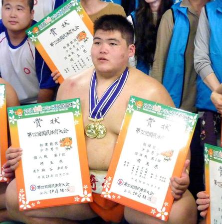　相撲少年個人と団体の２冠を達成し、賞状を手に記念撮影に応じる納谷幸之介（共同）