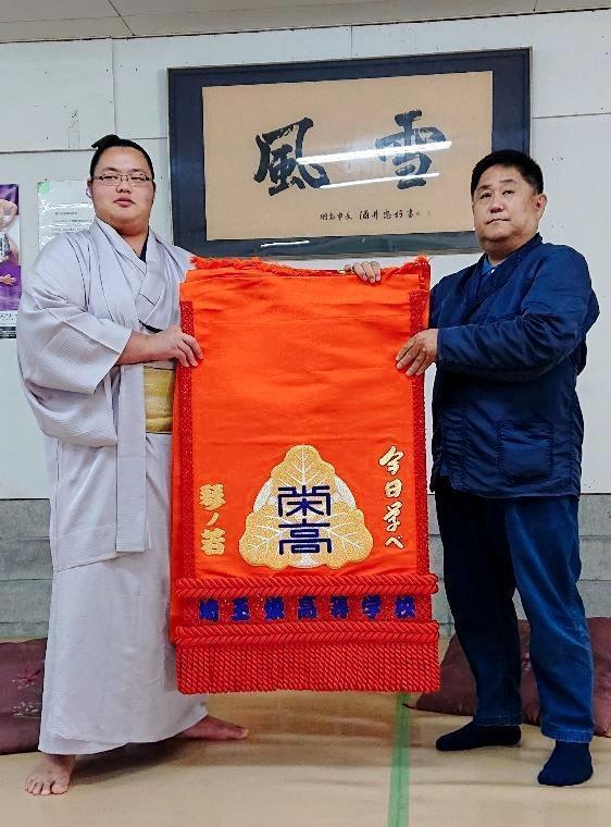 　母校・埼玉栄高の恩師・山田道紀監督（右）から母校の化粧まわしを贈呈された琴ノ若