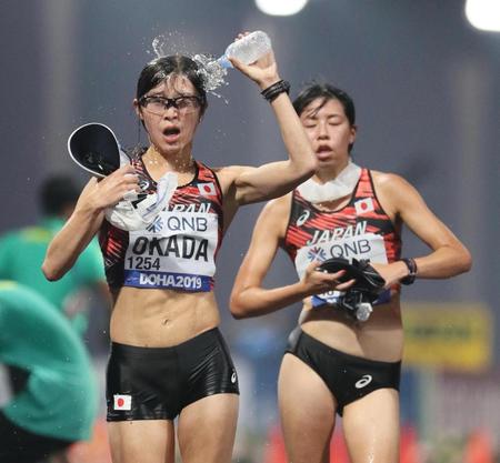 　女子２０キロ競歩で頭に水を掛けながらレースする岡田久美子（左）と藤井菜々子
