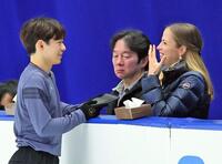 　公式練習でカロリナ・コストナーコーチ（右）と笑顔で話す鍵山優真。中央は鍵山正和コーチ
